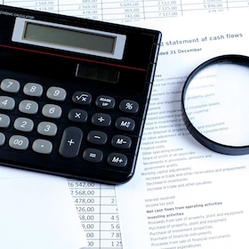 calculator, magnifier on financial reports. Business concept