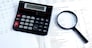 calculator, magnifier on financial reports. Business concept