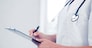 healthcare and medical concept - female doctor with stethoscope writing prescription