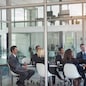 Executive, meeting and group in office room for corporate planning, strategy or business training. Management, people at table and businessman or speaker, mentor and professional advice to company.