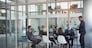 Executive, meeting and group in office room for corporate planning, strategy or business training. Management, people at table and businessman or speaker, mentor and professional advice to company.