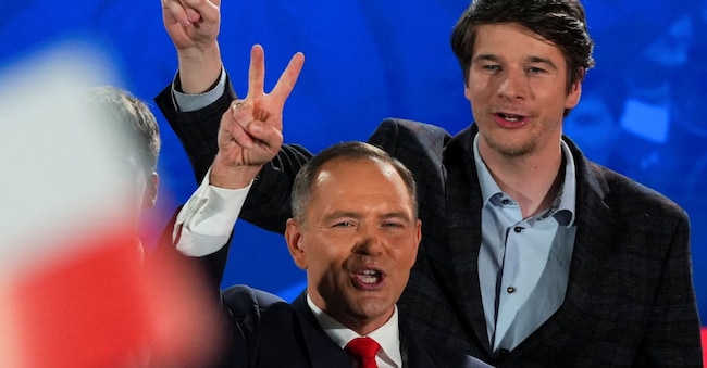 Karol Nawrocki, candidato del partito di opposizione di destra nazionalista Pis, e il suo figlio Antoni, mostrano il segno della vittoria dopo i risultati delle presidenziali polaccheREUTERS/Aleksandra Szmigiel