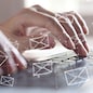 Email concept. Close up of business woman typing on computer keybord with email icons, internet network on virtual screen