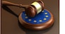 European Union laws, legal system and parliament concept with a 3d render of a gavel on a wooden desktop and the EU flag.