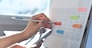 Event planner timetable agenda plan on organize schedule event. Business woman checking planner on mobile phone and taking note on calendar desk on office table. Calendar event plan, work planning, project management concept