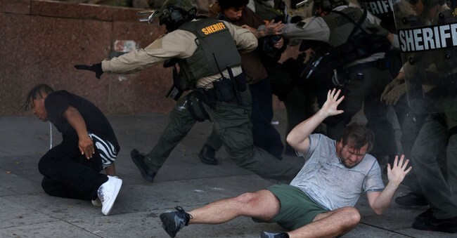 Mmanifestanti reagiscono a terra durante uno scontro con le forze dell’ordine durante una protesta contro i controlli federali sull’immigrazione, a Los Angeles, California, Stati Uniti, 11 giugno 2025 