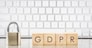 Close keypad lock with word GDPR on wooden cubes, white keyboard on background. European general data protection regulation, personal information, data privacy concepts.