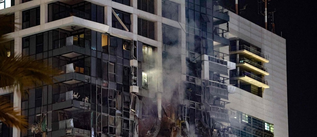 Un edificio in fiamme a Tel Aviv, colpito da un missile iraniano (Photo by Jack GUEZ / AFP)