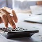 accountant working on desk using calculator for calculate finance report in office