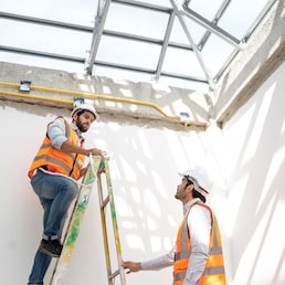 Engineer technician watching team of workers on high steel platform at construction site,Engineer working on construction building site.