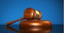 Law, justice and legal system concept with a wooden gavel judge symbol on blue background.