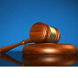 Law, justice and legal system concept with a wooden gavel judge symbol on blue background.
