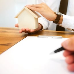 Real Estate agent with customer making contract signature and analyzing valuation