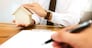 Real Estate agent with customer making contract signature and analyzing valuation