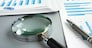 TRN4TB Magnifying glass and business report for auditing.