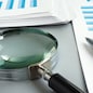 TRN4TB Magnifying glass and business report for auditing.