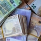 Bundles of European banknotes tied with rubber bands.