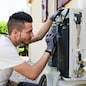 handsome young man electrician installing air conditioning in a client house