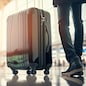 A business traveler walking through the airport departure area with a suitcase, bright sunlight in background. Generative Ai.