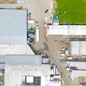 Aerial view of goods warehouse. Logistics center in industrial city zone from above. Aerial view of trucks loading at logistic center