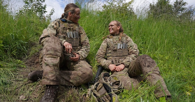 La ventenne Katrine, a destra, parla con un'altra soldatessa durante le esercitazioni finali in un'area di addestramento vicino alla caserma dell'Esercito reale danese a Hovelte, 25 chilometri a nord di Copenaghen, in Danimarca. (Foto AP/James Brooks)