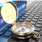 Online navigation. Compass on laptop keyboard. 3d