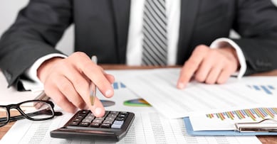 Businessman working with using a calculator to calculate the numbers. Finance accounting concept