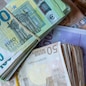 Bundles of European banknotes tied with rubber bands.