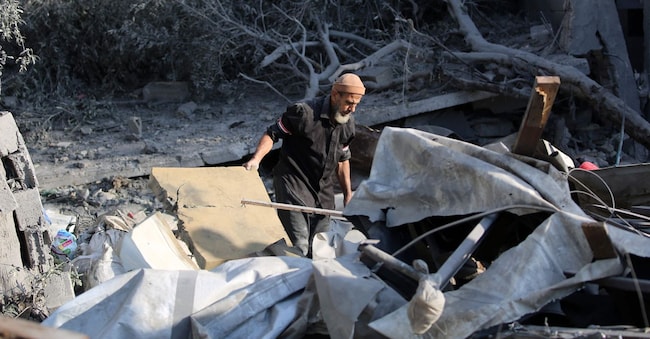 Un uomo palestinese controlla i danni dopo un attacco israeliano notturno che ha colpito Nuseirat, nella Striscia di Gaza centrale, il 13 luglio 2025. (Foto di Eyad BABA / AFP)