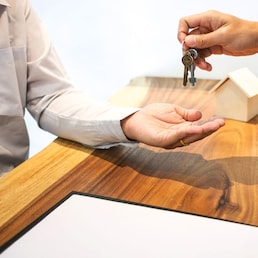 Real Estate agent with customer making contract signature giving a key buy / rent a house