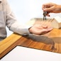 Real Estate agent with customer making contract signature giving a key buy / rent a house