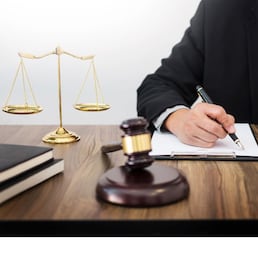 lawyer hand writes the document in court (justice, law) with sounding block and golden Weight.