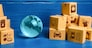 Planet Earth globe and cardboard boxes mass consumption products. Delivering goods around the world. International trade and transportation of goods. Shipping freight. Transnational business industry.