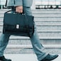 Close-up of businessman with a briefcase running in a city street. Hurrying to work.