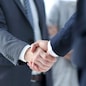 closeup of handshake of business partners on the background of business team