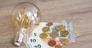 rise of electricity prices concept - light bulb with Euro banknotes and coins