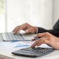 Asian businessman hands calculating number, graph, chart audit planning accountancy on business report. Asian professional Business man hands using calculator counting tax financial bill. Tax audit Finacial concept.