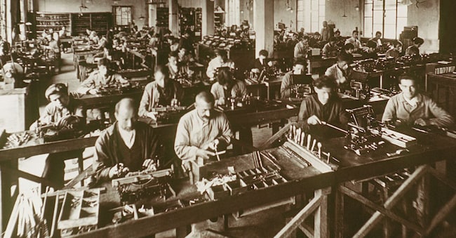 Storia dell'industria - Montaggio manuale delle prime macchine da scrivere della Olivetti, Italia, 1920. (Fototeca Gilardi / AGF)