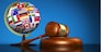 International law systems, justice, human rights and global business education concept with world flags on a school globe and a gavel on a desk on blue background.
