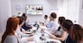 Group Of Businesspeople Having Video Conference With Another Business Team In Office