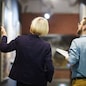 Back view portrait of two museum workers discussing paintings walking in art gallery, copy space