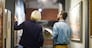 Back view portrait of two museum workers discussing paintings walking in art gallery, copy space