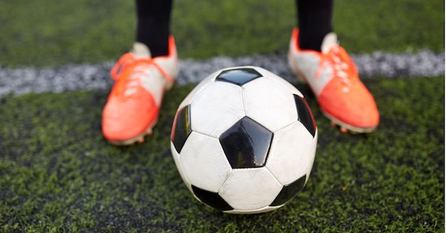 sport, football and people - soccer player playing with ball on field