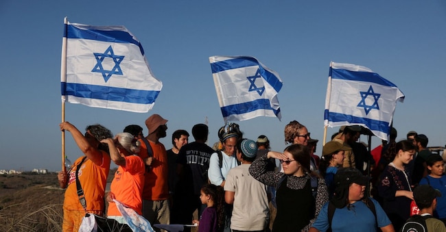 Attivisti della destra israeliana partecipano a una manifestazione organizzata da gruppi di coloni per promuovere il reinsediamento di Israele a Gaza, sul lato israeliano del confine tra Israele e Gaza, vicino al confine, 30 luglio 2025. REUTERS/Ronen Zvulun