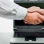 Woman and man shaking hands on the background of opened laptop