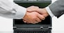 Woman and man shaking hands on the background of opened laptop