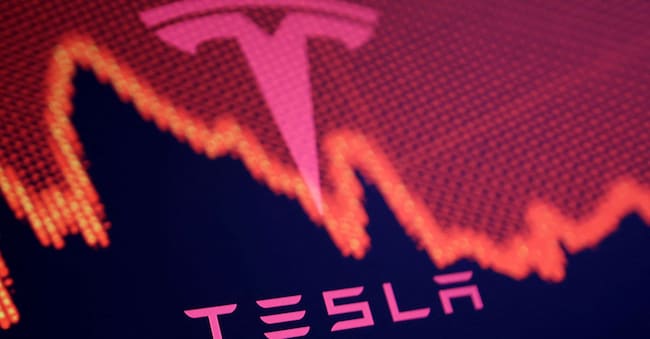 Il logo Tesla e l’andamento negativo in Borsa. REUTERS/Dado Ruvic/Illustration