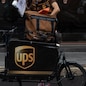 MILAN, ITALY - SEPTEMBER 23: A delivery man for United Parcel Service (UPS) handles a parcel next to his cargo bike on September 23, 2020 in Milan, Italy. Since the end of lockdown Milan authorities have added a further 35 kilometers of pop-up bike lanes and cycle paths and encouraged cycling and riding e-scooters as a safer form of transport away from jam-packed buses or subway trains, in order to promote social distancing in response to COVID-19. (Photo by Emanuele Cremaschi/Getty Images)