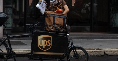 MILAN, ITALY - SEPTEMBER 23: A delivery man for United Parcel Service (UPS) handles a parcel next to his cargo bike on September 23, 2020 in Milan, Italy. Since the end of lockdown Milan authorities have added a further 35 kilometers of pop-up bike lanes and cycle paths and encouraged cycling and riding e-scooters as a safer form of transport away from jam-packed buses or subway trains, in order to promote social distancing in response to COVID-19. (Photo by Emanuele Cremaschi/Getty Images)