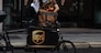 MILAN, ITALY - SEPTEMBER 23: A delivery man for United Parcel Service (UPS) handles a parcel next to his cargo bike on September 23, 2020 in Milan, Italy. Since the end of lockdown Milan authorities have added a further 35 kilometers of pop-up bike lanes and cycle paths and encouraged cycling and riding e-scooters as a safer form of transport away from jam-packed buses or subway trains, in order to promote social distancing in response to COVID-19. (Photo by Emanuele Cremaschi/Getty Images)